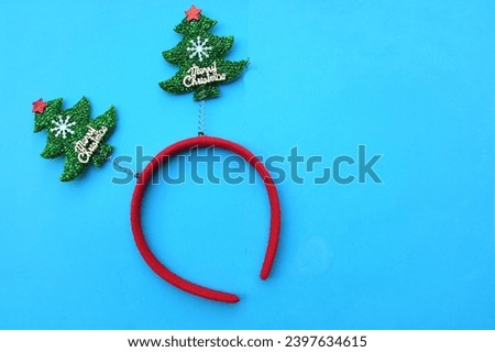 decorated Beautiful headband funny christmas trees isolate on a blue backdrop.
concept of joyful Christmas party,New year is coming soon, festive season decoration with Christmas elements