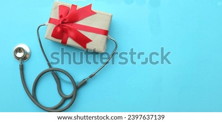 medical stethoscope with gift box isolated on a blue pastel background. concept christmas and new year.horizontal photo