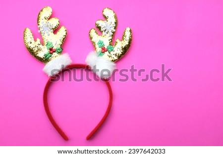 cute Headband Christmas, Christmas deer horns isolate on a pink backdrop. concept of joyful Christmas party,New year is coming soon, festive season decoration with Christmas elements