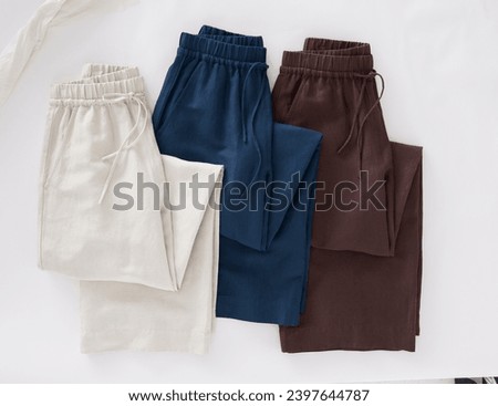 stack of women's clothes pant's on white background. can be used for showcasing clothing items. copy space, close up, top view. clothes ,sale, shopping, fashion, style concept. Royalty-Free Stock Photo #2397644787