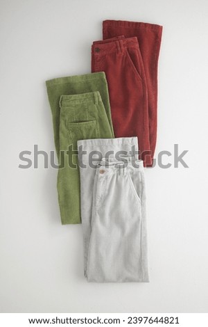 stack of women's clothes pant's on white background. can be used for showcasing clothing items. copy space, close up, top view. clothes ,sale, shopping, fashion, style concept.