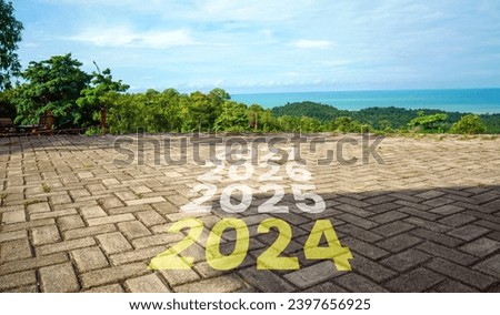 New year 2024 or straight forward concept. The years 2024, 2025 are written on the road on the hill with a view of the beach. Concept of planning, goals, challenges, new year resolutions.