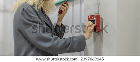Foreman or worker pushing fire alarm on the wall. A fire! or Emergency case at the factory building. Emergency of Fire alarm or alert or bell warning equipment