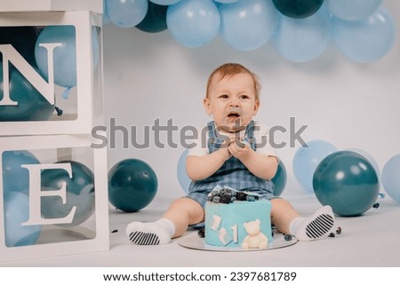 Baby boy playing with a cake during cake smash birthday party