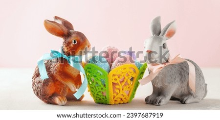 Ceramic rabbits and colored eggs in the basket. Easter holiday concept