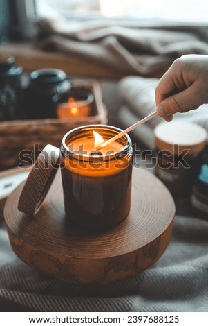 Match in hand lighting candles, aesthetics.