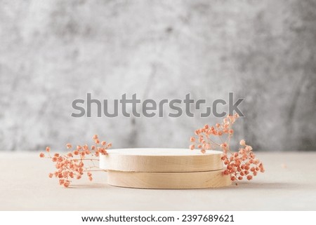 Empty round wooden podium for product presentation or cosmetics,  gypsophila flowers on  background.  Mock up concept. Royalty-Free Stock Photo #2397689621