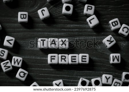 spelling of the word "Tax Free" from alphabet blocks on dark wood texture background, concept and design for financial theme