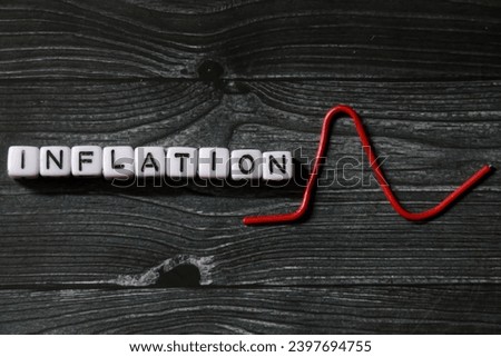 spelling of the word "Inflation" from alphabet blocks on dark wood texture background, concept and design for financial theme