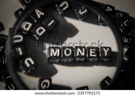spelling of word "money" from alphabet blocks on dark wood texture background close up with loop, concept and design for business theme