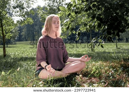 meditation Woman meditates in nature outdoor.At ground level, a relaxed woman meditates and breathes while sitting in Lotus pose next to fragrant incense during a yoga class in the garden