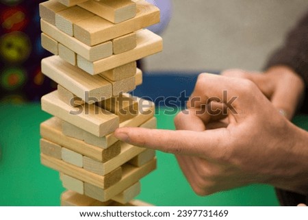 close-up of children's hands building a tower of multi-colored bars