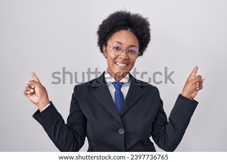 Beautiful african woman with curly hair wearing business jacket and glasses smiling confident pointing with fingers to different directions. copy space for advertisement 