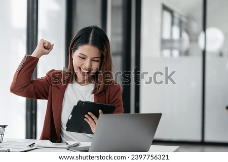 Business woman are excited business success with inspiration from their excellent financial results that are happy working in a modern office on a Tablet.