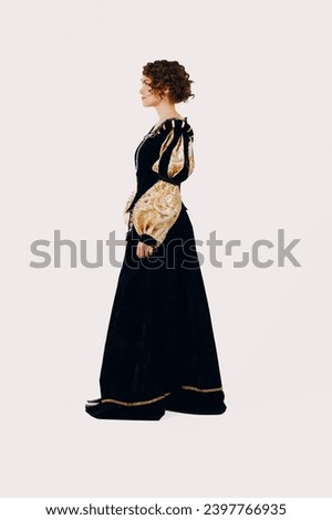 Portrait of a young aristocratic woman dressed in a medieval dress on white background. Side view