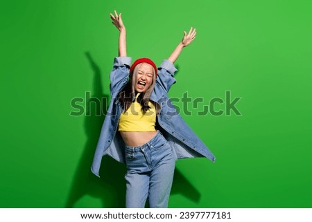 Photo portrait of lovely young lady dance raise hands scream sing have fun wear trendy jeans garment isolated on green color background