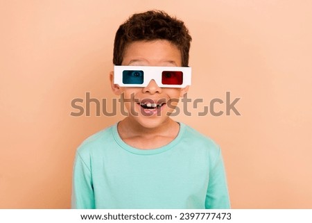 Portrait of astonished cheerful schoolkid toothy smile watch movie 3d glasses isolated on beige color background