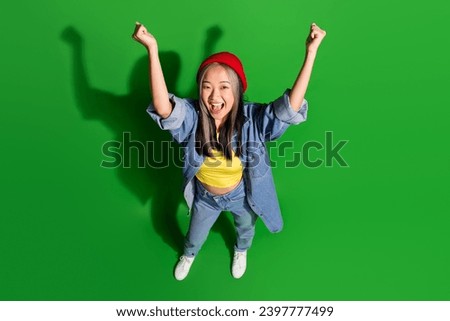 Full length top view photo of lucky excited lady wear denim jacket rising fists empty space isolated green color background Royalty-Free Stock Photo #2397777499