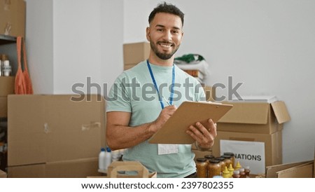 Young arab man volunteer taking notes smiling at charity center