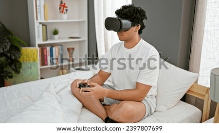 Young latin man playing video game using virtual reality glasses and joystick at bedroom