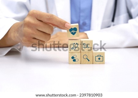 Hand holding a wooden block cube with healthcare medical symbol, heart rate icon. Medical and health concept.