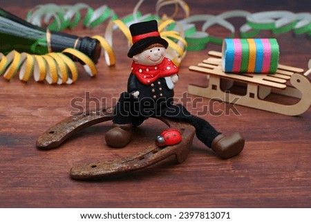 New Year's Eve and New Year's decorations. Chimney sweep sitting on horseshoe with streamers. Royalty-Free Stock Photo #2397813071
