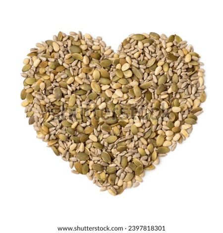 Mixture of dried salad seeds in heart shape isolated on white background close up 