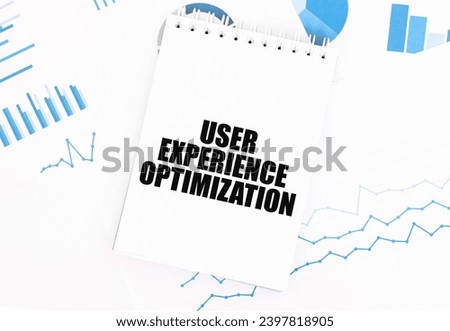 White notepad with text USER EXPERIENCE OPTIMIZATION on the financial documentation. Finance and business concept