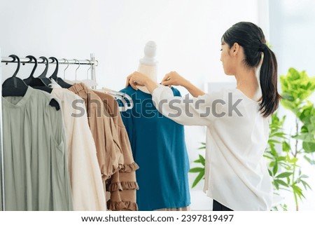 A shop clerk working in modern boutique.  Royalty-Free Stock Photo #2397819497