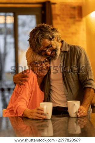 Smiling senior couple hugging while having coffee in cafe celebrating Valentine's Day together