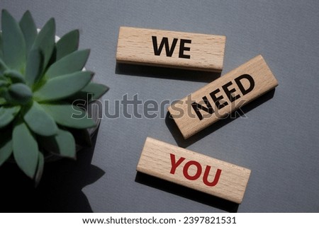 We need You symbol. Wooden blocks with words We need you. Beautiful grey background with succulent plant. Business and We need You concept. Copy space
