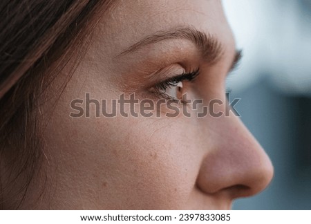 Portrait of fragment young woman face. Eye, eyelashes, brows, nose. Side view. Closeup.