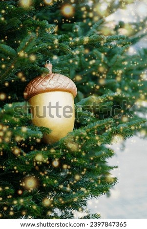 Christmas decoration in the form of a golden acorn for the Christmas tree and bokeh background