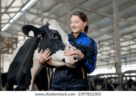 Happy young woman farm worker hugging cow as sign of concern for animal health care. Concept agriculture cattle livestock farming industry. Royalty-Free Stock Photo #2397852303