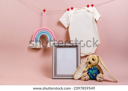 Gender party. Baby bodysuit, rainbow toy, plush bunny, photo frame mockup. Children's room decoration.