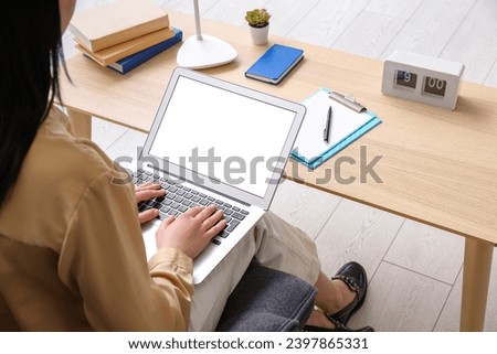 Young woman with laptop sitting on chair