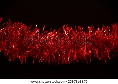 Tinsel. Red glitter on black background. Trumpery close up view Royalty-Free Stock Photo #2397869975