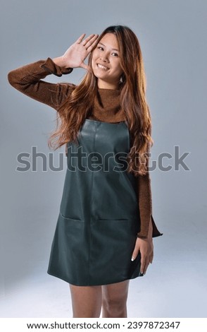 Photo of  young woman 
wear casual dress posing 
in studio
