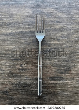 interior top view photo of a silver metal fork on a wood work top background table
