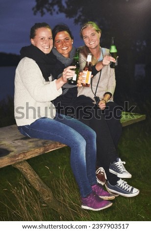 Friends, portrait and beer outdoor at night for camping adventure, nature celebration or group connection. Woman, face and smile for alcohol drinking or cheers toast for summer, travel or vacation