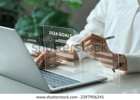 2024 New Year goals, plan, and action concepts. BusinessWoman using a laptop with a virtual goal 2024 year checklist.New Year's resolutions plan. Goal achievement and success in 2024. business target. Royalty-Free Stock Photo #2397906241