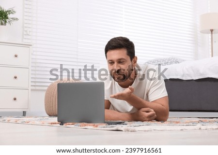 Man blowing kiss during video chat via laptop at home. Long-distance relationship