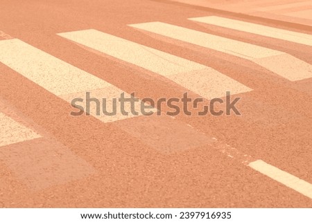 Innovative pedestrian crossing in town with optical 3D effect, hoping to further attract drivers attention toned in trendy pantone Peach Fuzz color of Year 2024