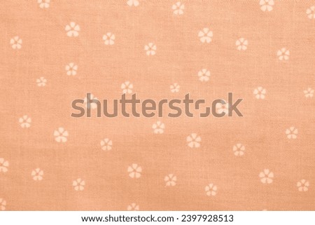 Peach fuzz cotton fabric with small flowers texture. Floral textile background