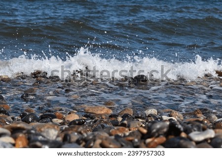 Close Up of a small wave crashing against small rocks
