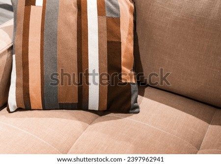 Multicolored pillow on yellow sofa background. New trending PANTONE 13-1023 Peach Fuzz colour of 2024 year  Royalty-Free Stock Photo #2397962941