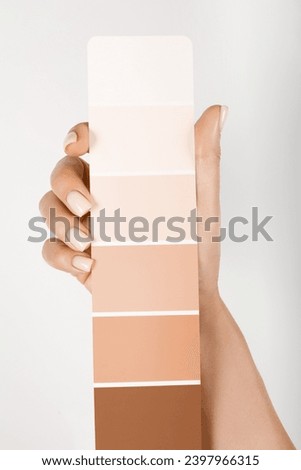 Hand holding Color samples palette design catalog. New trending PANTONE 13-1023 Peach Fuzz colour of 2024 year  Royalty-Free Stock Photo #2397966315