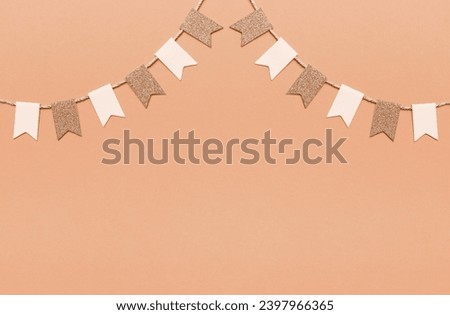 Party flags garlands set on pink background. New trending PANTONE 13-1023 Peach Fuzz colour of 2024 year 