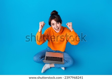 Full length top view photo of positive lucky lady wear knitted pullover rising fists winning game modern device isolated blue color background