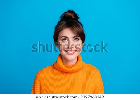 Photo of cheerful excited lady wear knitted pullover looking up empty space isolated blue color background
